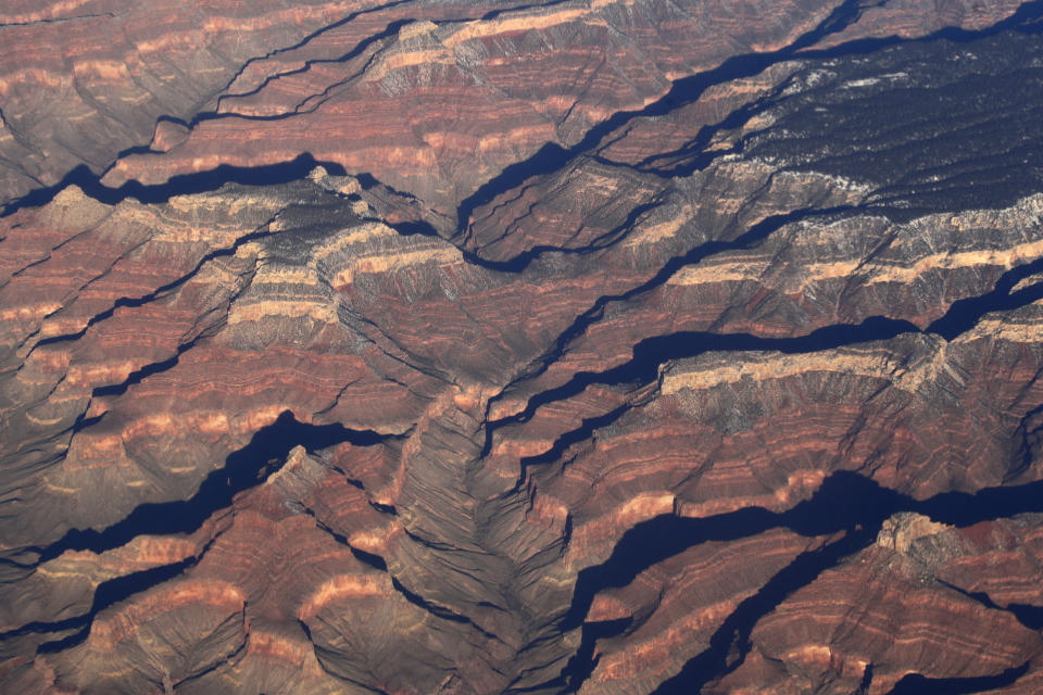 FILE - This Dec. 17, 2019 file aerial photo shows Arizona's Grand Canyon. A leading conservation agency is warning that climate change is damaging the U.N.' most cherished heritage sites. Climate change is increasingly damaging the U.N.’s most cherished heritage sites, a leading conservation agency warned Wednesday Dec. 2, 2020, reporting that Australia’s Great Barrier Reef and dozens of other natural wonders are facing severe threats. (AP Photo/Charlie Riedel, File)