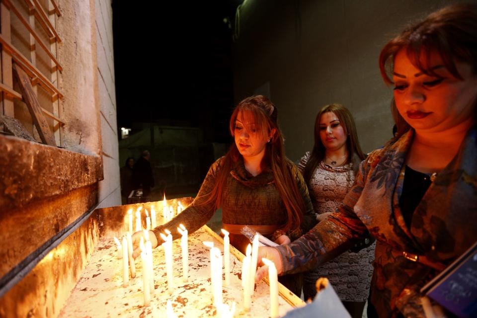 Iraqi Christians light candles during a mass on Christmas eve at Sacred Heart Catholic Church in Baghdad, December 24, 2014. REUTERS/ Thaier Al-Sudani (IRAQ - Tags: RELIGION SOCIETY)