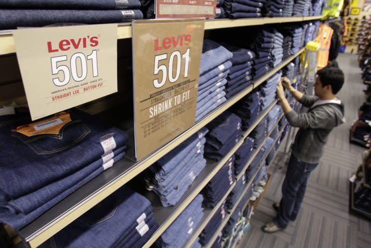 Salesman Jesus Ibarra straightens out Levi's jeans at a store in Hayward, Calif. (Photo: Paul Sakuma/AP)