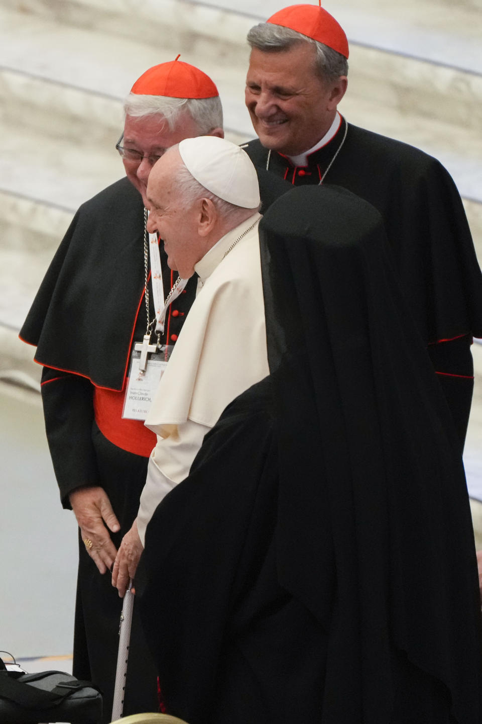 Cardinal Jean-Claude Hollerich, left, and Secretary General of the Synod of Bishops Cardinal Mario Grech, right greet Pope Francis as he arrives for the opening session of the 16th General Assembly of the Synod of Bishops in the Paul VI Hall at The Vatican, Wednesday, Oct. 4, 2023. Pope Francis is convening a global gathering of bishops and laypeople to discuss the future of the Catholic Church, including some hot-button issues that have previously been considered off the table for discussion. Key agenda items include women's role in the church, welcoming LGBTQ+ Catholics, and how bishops exercise authority. For the first time, women and laypeople can vote on specific proposals alongside bishops. (AP Photo/Gregorio Borgia)