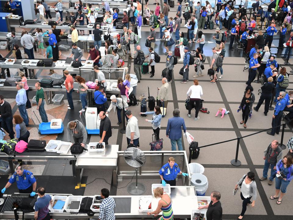 Travelers lining up in security lines at Denver International Airport.
