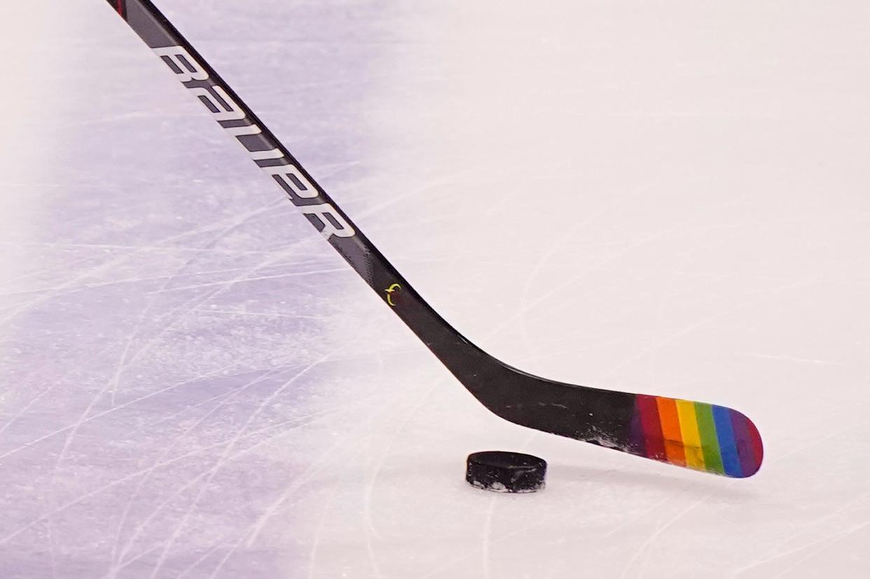 Florida Panthers center Eetu Luostarinen uses a stick with the LGBT pride flag on it before the start of a hockey game against the Nashville Predators on March 20, 2021.