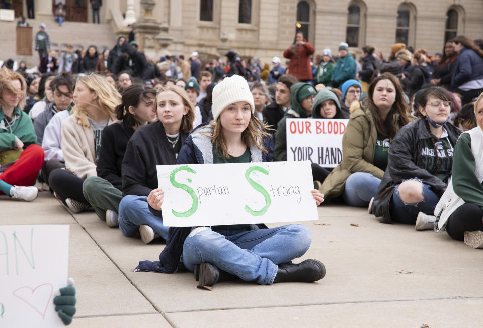 Protesters hold signs to protest gun violence at a student sit in at the Michigan Capitol building following a mass shooting at Michigan State University earlier in the week,in Lansing, Mich., on Wednesday, Feb. 15, 2023. (Brice Tucker/The Flint Journal via AP)