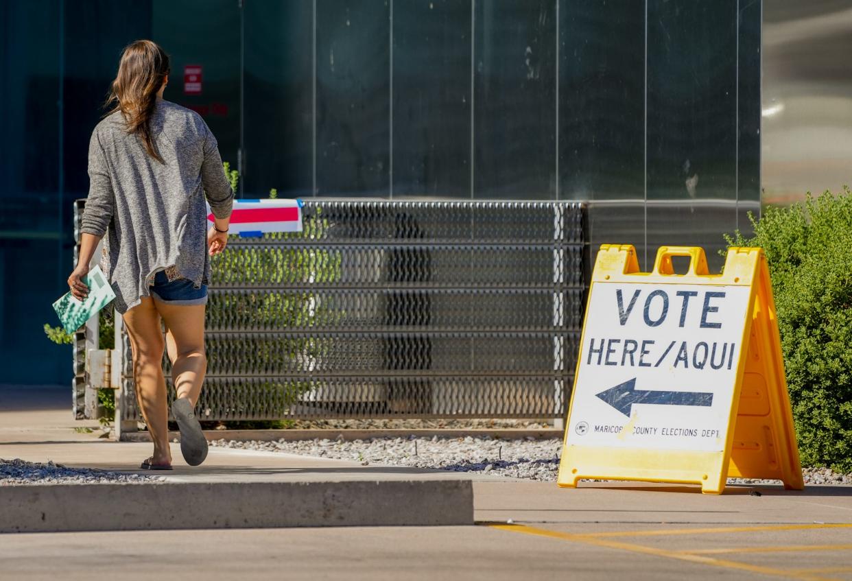 People walk into the Burton Barr Library and voting center to cast their votes in the primary election on Aug. 2, 2022, in Phoenix.