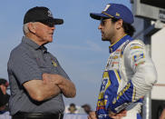 Team owner Joe Gibbs, left, talks with Chase Elliott before qualifications for Sunday's NASCAR Cup Series auto race at Charlotte Motor Speedway in Concord, N.C., Thursday, May 23, 2019. (AP Photo/Chuck Burton)