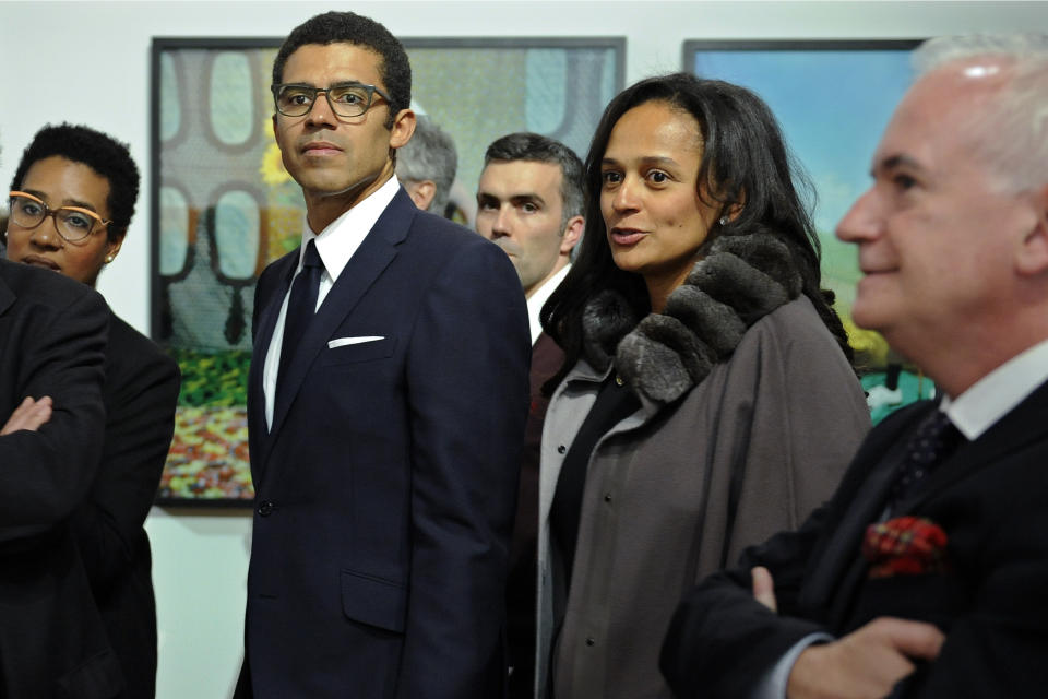 In this March 5, 2015 photo, Isabel dos Santos, reputedly Africa's richest woman, and her husband and art collector Sindika Dokolo, center left, attend the opening of an art exhibition featuring works from his collection in Porto, Portugal. On Monday, Jan. 6, 2020, Angolan Foreign Minister Manuel Augusto said that there is no political motivation behind the government's demand for more than $1 billion from dos Santos, her husband and a Portuguese business partner. Isabel dos Santos is a daughter of Jose Eduardo dos Santos, who ruled the oil- and diamond-rich nation for 38 years until 2017. (AP Photo/Paulo Duarte)