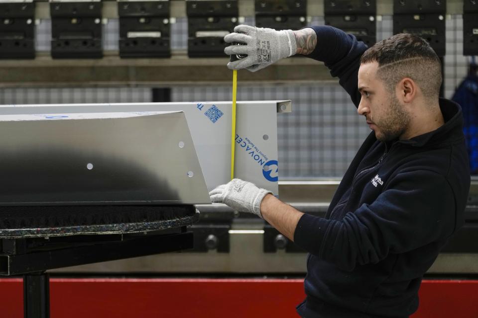 A worker checks measurements of a pool section at the Myrtha Pools factory, in Castiglione delle Stiviere, northern Italy, Tuesday, March 12, 2024. Italian company Myrtha Pools is producing 24 pools for the Paris Olympics at its factory in Castiglione delle Stiviere, near Verona. The pools will be used for swimming, diving, water polo, artistic swimming and training areas in Paris. It's the sixth Olympics that Myrtha will be providing pools for. (AP Photo/Luca Bruno)