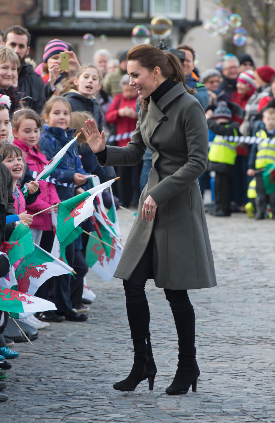 <p>For a day in Wales, Kate covered up in an olive green coat by Reiss and knee-length black boots by Italian brand, Aquatalia.</p><p><i>[Photo: PA]</i></p>