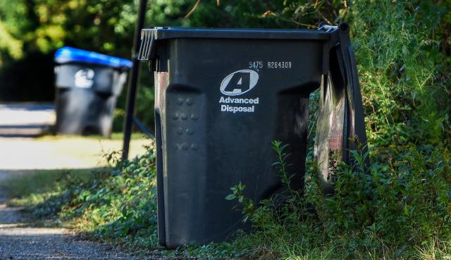 Garbage cans sit along the road near Prattville, Ala., on Friday October 22, 2021. Customers are complaining that Advanced Disposal is not picking up garbage on schedule.