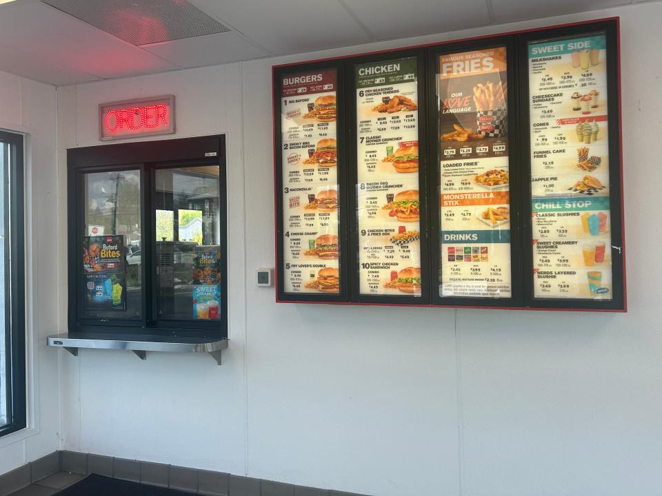 walk-up order window next to a big menu sign at checkers