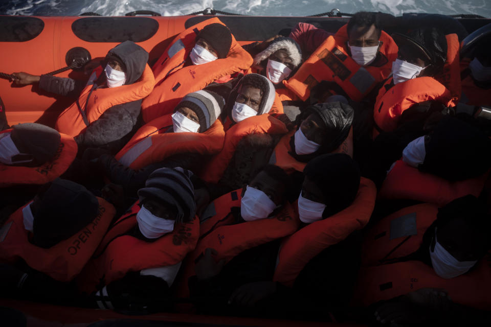 Migrants are rescued by aid workers of the Spanish NGO Open Arms, after fleeing Libya on board a precarious wooden boat in the Mediterranean sea, about 110 miles north of Libya, on Saturday, Jan. 2, 2021. (AP Photo/Joan Mateu)