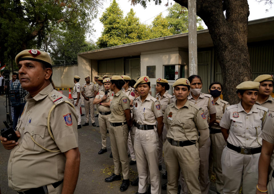 Policemen stand guard as Indian Sikhs protesting against the pulling down of Indian flag from the Indian High Commission building in London gather outside the British High Commission in New Delhi, India, Monday, March 20, 2023. Footage posted on social media showed a man detach the Indian flag from a balcony of the building while a crowd of people below waving bright yellow “Khalistan” banners appeared to encourage him. London’s Metropolitan Police force said a man was arrested on suspicion of violent disorder outside the diplomatic mission on Sunday afternoon. (AP Photo/Manish Swarup)