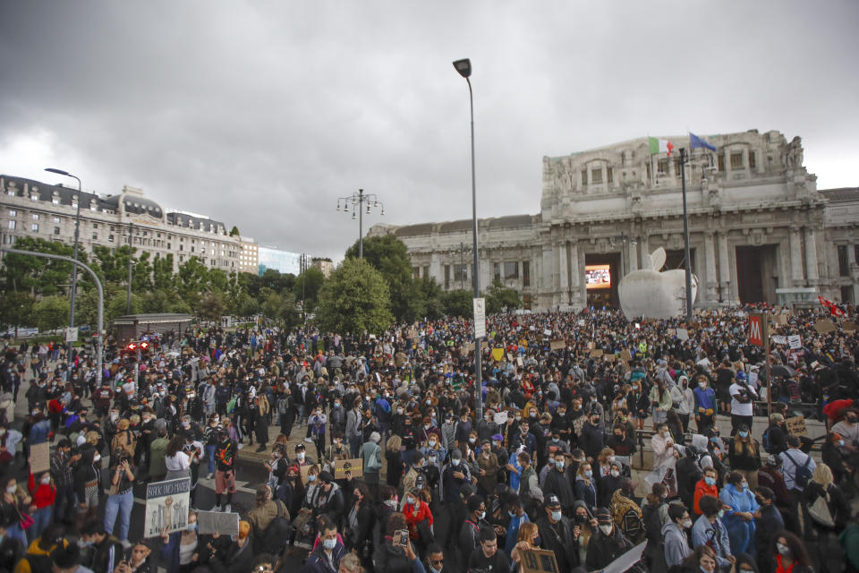 People gather calling for justice for George Floyd, who died May 25 after being restrained by police in Minneapolis, USA, in Milan, Italy, Sunday, June 7, 2020. People have been protesting throughout Italy, to denounce the police killing of George Floyd and show solidarity with anti-racism protests in the U.S. and elsewhere. (AP Photo/Luca Bruno)