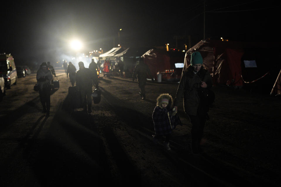 Refugees fleeing war in neighboring Ukraine walk toward a train at the Medyka border crossing, Poland, Thursday, March 10, 2022. (AP Photo/Daniel Cole)
