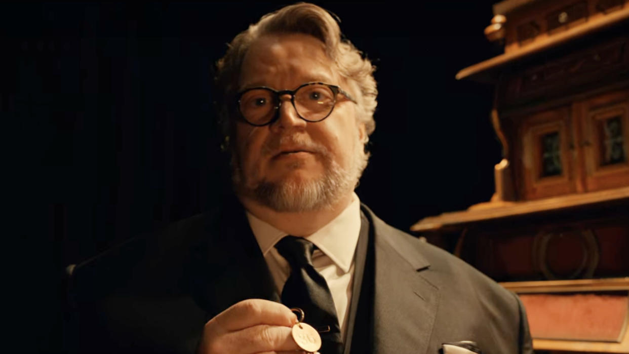  Guillermo del Toro holding a key in front of the cabinet in Guillermo del Toro's Cabinet of Curiosities. 