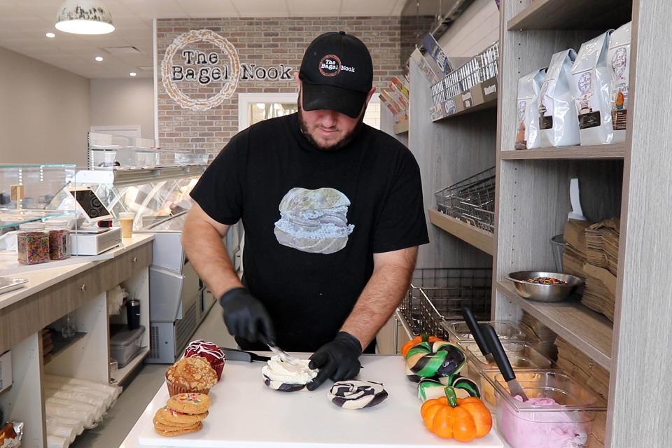 Alex Berkowitz, co-owner of The Bagel Nook, prepares a Halloween-themed bagel in the newest location of his shop in Freehold Township.