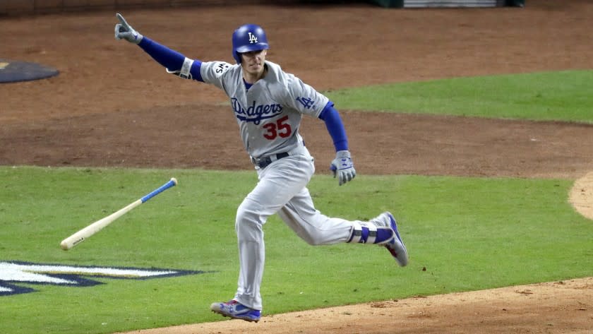 Cody Bellinger flips his bat as he hits an RBI double in the ninth inning to give the Dodgers a 2-1 lead.