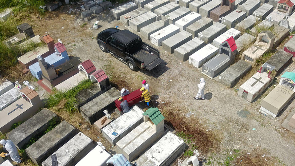 Workers are seen burying a coffin at Maria Canals cemetery in the outskirts of Guayaquil, Ecuador, on April 12, amid the new coronavirus outbreak. Source: Getty