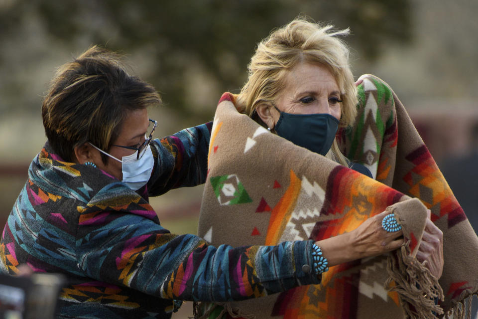 FILE - Navajo Nation Council Member Eugenia Charles Newton helps first lady Jill Biden cover up with a Navajo Pendleton blanket during a live radio address to the Navajo Nation at the Window Rock Navajo Tribal Park & Veterans Memorial in Window Rock, Ariz., on April 22, 2021.(Mandel Ngan/Pool via AP, File)