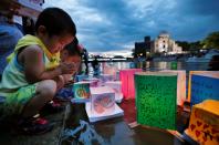 <p>Children pray after releasing paper lanterns on the Motoyasu river facing the Atomic Bomb Dome in remembrance of atomic bomb victims on the 72nd anniversary of the bombing of Hiroshima, western Japan, Aug. 6, 2017, in this photo taken by Kyodo. (Photo: Kyodo via Reuters) </p>