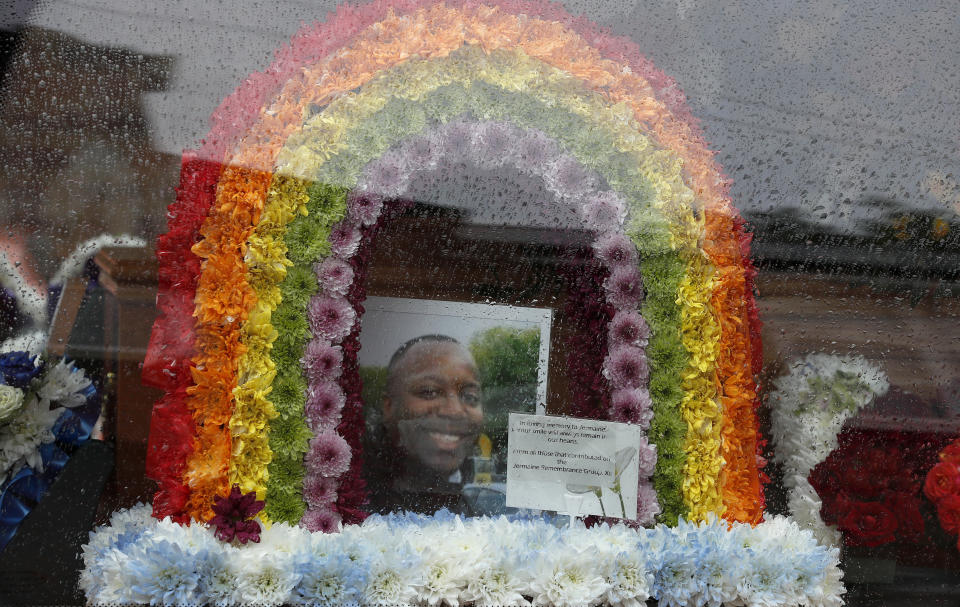 In this photo taken on Thursday, June 11, 2020, a view of photo and floral tribute for Jermaine Wright, a pharmacist and a referee of the Hackney Marshes grassroots football league, inside the hearse on the day of his funeral, in London. Wright, affectionately known as Mr. Hackney Marshes, served as both an on-field referee and a behind-the-scenes catalyst in the Hackney & Leyton Sunday Football League — as vice chairman, schedule secretary, results secretary, press officer, and head official before he died on April 27, 2020 from COVID-19. (AP Photo/Frank Augstein)