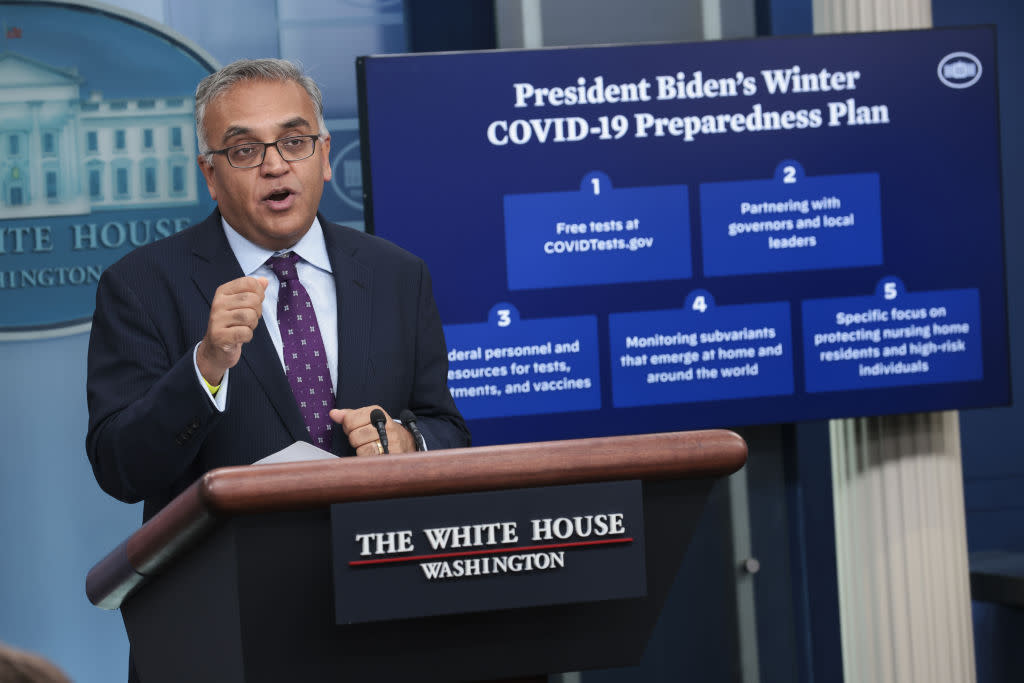 Ashish Jha, White House COVID-19 response coordinator stands at a podium labeled: The White House, Washington and stands next to a poster labeled: President Biden's winter COVID-19 preparedness plan.