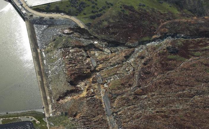 This photo shows erosion caused when overflow water cascaded down the emergency spillway of the Oroville Dam, Monday, Feb. 13, 2017, in Oroville, Calif. The water level dropped Monday at the nation's tallest dam, easing slightly the fears of a catastrophic spillway collapse that prompted authorities to order people to leave their homes downstream. (AP Photo/Rich Pedroncelli)