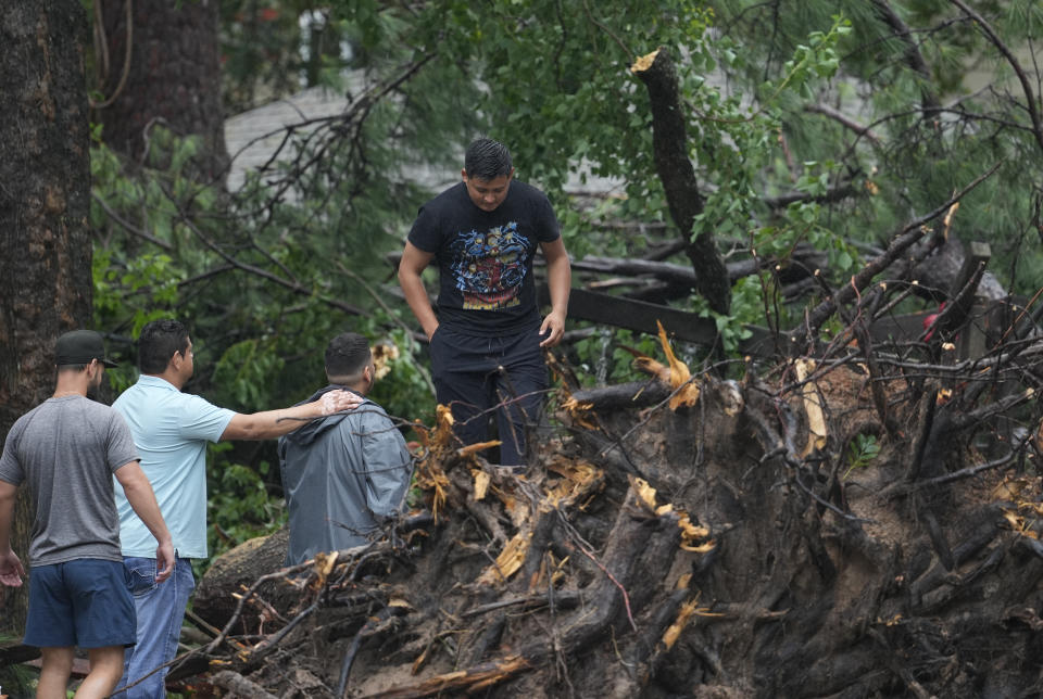 CORRECTION CORRECTS NAME People gather outside a home in the 17400 block of Rustic Canyon Trail where Maria Loredo, 74, died after a tree fell on her second story bedroom during Hurricane Beryl Monday, July 8, 2024, in Houston (Melissa Phillip/Houston Chronicle via AP)