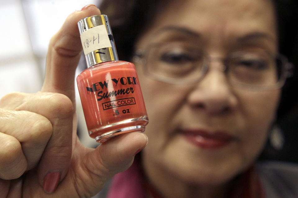 Loann Tran, co-owner of Happy Nails in Salinas, Calif., holds up a bottle of nail polish that was tested and found to contain toluene and formaldehyde, despite being labeled as free of those toxic chemicals, after a news conference at the Laney College School of Cosmetology in Oakland, Calif., Tuesday, April 10, 2012. Some nail polishes commonly found in California salons and advertised as free of a so-called ìtoxic trioî of chemicals actually have high levels of agents known to cause birth defects,according to state chemical regulators. (AP Photo/Jeff Chiu)