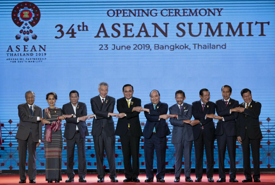 Leaders of the Association of Southeast Asian Nations (ASEAN) from left, Malaysian Prime FILE - In this June 23, 2019, file photo, South East Asian leaders pose for a group photo during the opening ceremony of the ASEAN leaders summit in Bangkok, Thailand. Southeast Asian leaders have pressed their call for self-restraint in the South China Sea as chief claimant China feuds with the U.S. over trade and territorial disputes flare anew between Beijing and the Philippines. (AP Photo/Gemunu Amarasinghe, File)