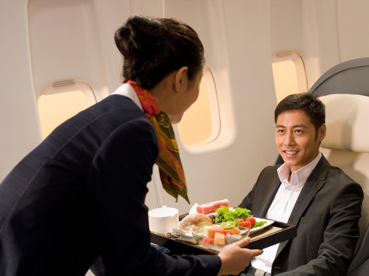 Flight attendant bringing food to a passenger