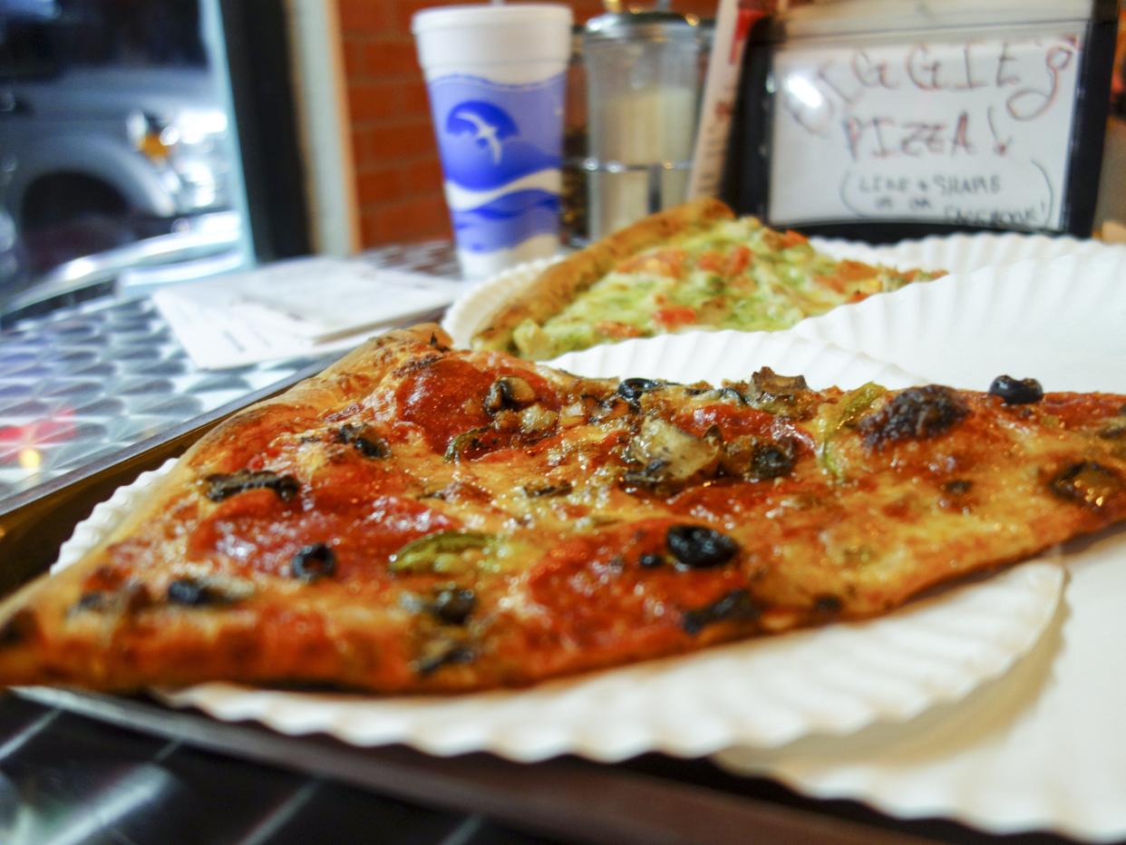 Biggie's Pizza: Brooklyn Deluxe Pie, foreground, with mozzarella, pepperoni, beef, sausage, green peppers, onions, black olives, mushrooms and extra virgin olive oil.