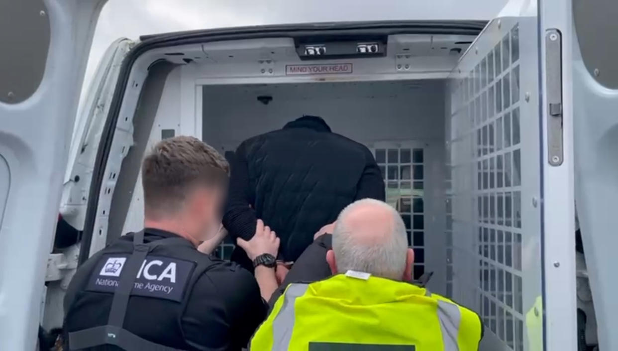 A man is arrested by National Crime Agency officers in Portsmouth on suspicion of people smuggling and money laundering (NCA/PA)