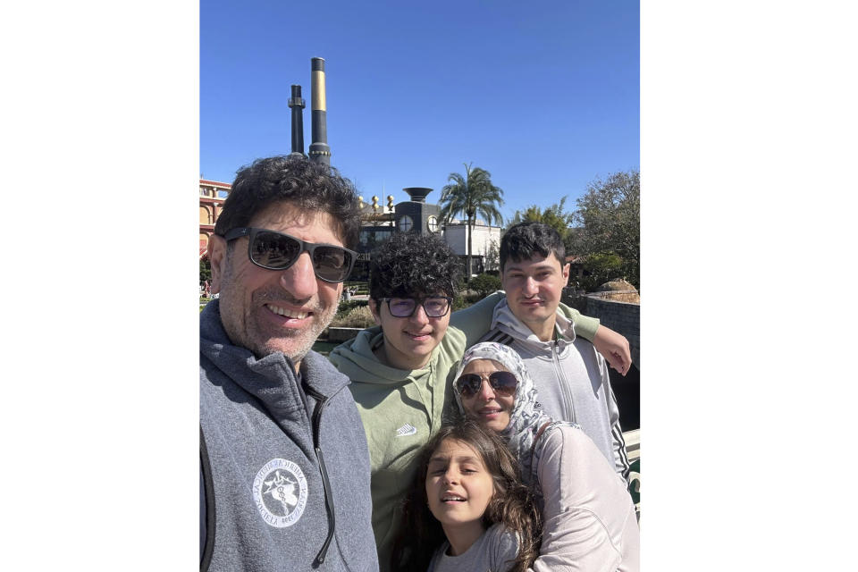 Dr. Ammar Ghanem, an ICU specialist from Detroit volunteering with the Syrian American Medical Society at one of Gaza's last functioning hospitals, left, poses with his family in Orlando, Fla., late Feb. 2024. A group of 35 foreign doctors on a volunteer mission to help at the hospital, including 22 Americans, have been trapped in Gaza by Israel’s seizure of the Rafah crossing into Egypt.