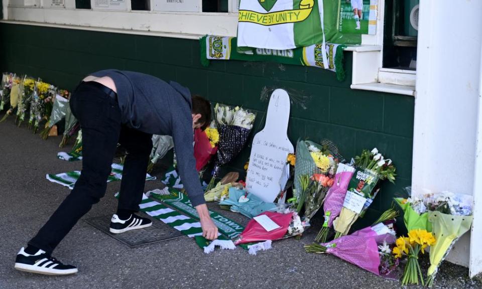 A fan leaves his scarf among tributes to Lee Collins, who died at the age of 32 in March.