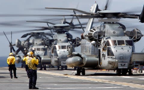 Crewmen direct a pair of CH-53 Super Stallion transport helicopters preparing to lift off from the USS Kearsarge in advance of Hurricane Maria - Credit: JONATHAN DRAKE/Reuters