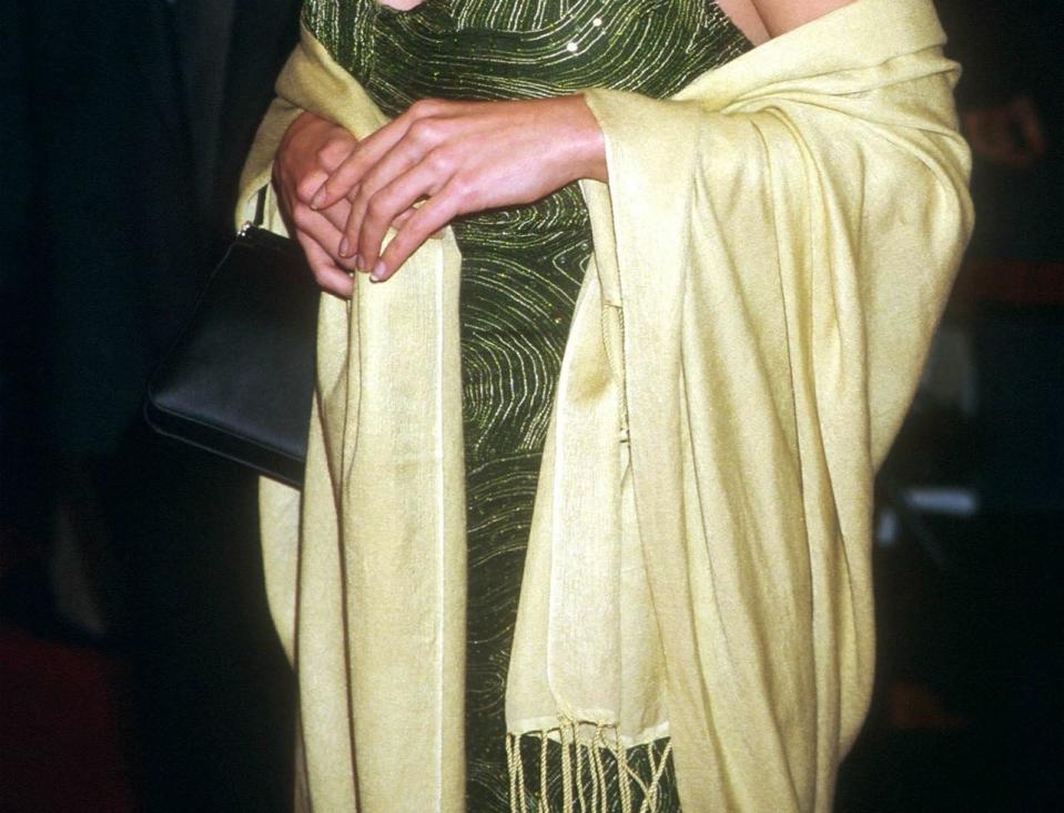 Crop of Neve Campbell attending the premiere of her new movie "Drowning Mona" February 28, 2000 wearing a yellow pashmina