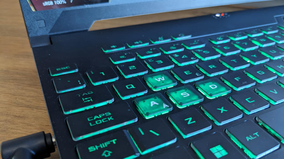 A black ASUS TUF Gaming A15 laptop on a wooden table