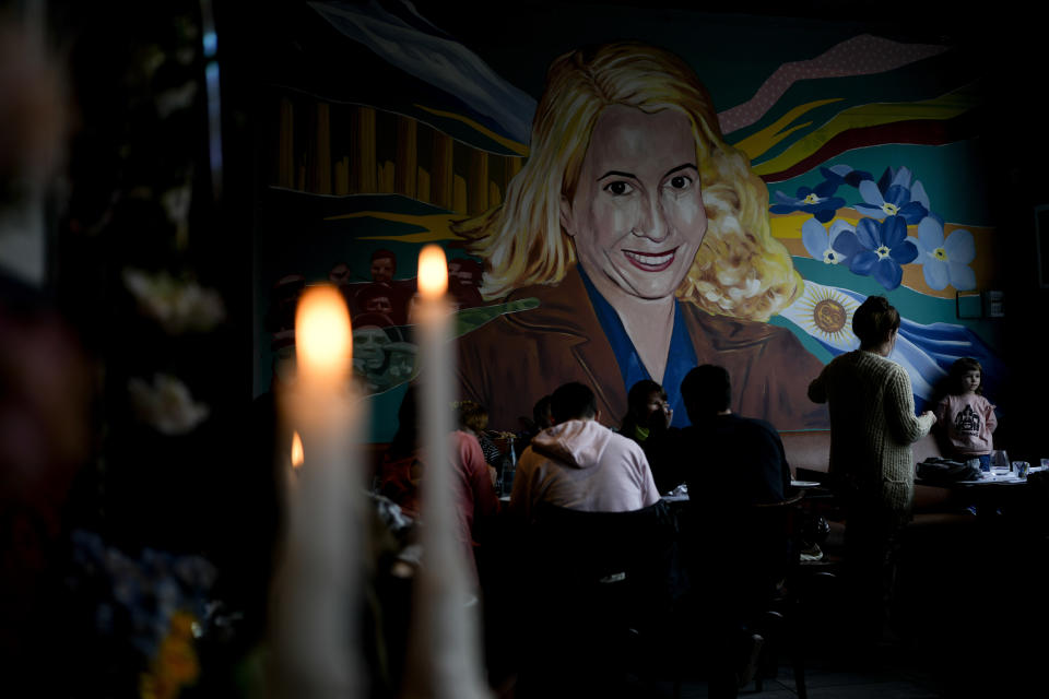 Candles burn near a mural of Argentina's late former first lady Maria Eva Duarte de Peron, better known as "Evita" at "El Santa Evita" restaurant in Buenos Aires, Argentina, Sunday, July 24, 2022. Argentines commemorate the 70th anniversary of the death of their most famous first lady on Tuesday, Evita who died of cancer on July 26, 1952, at the age of 33. (AP Photo/Natacha Pisarenko)