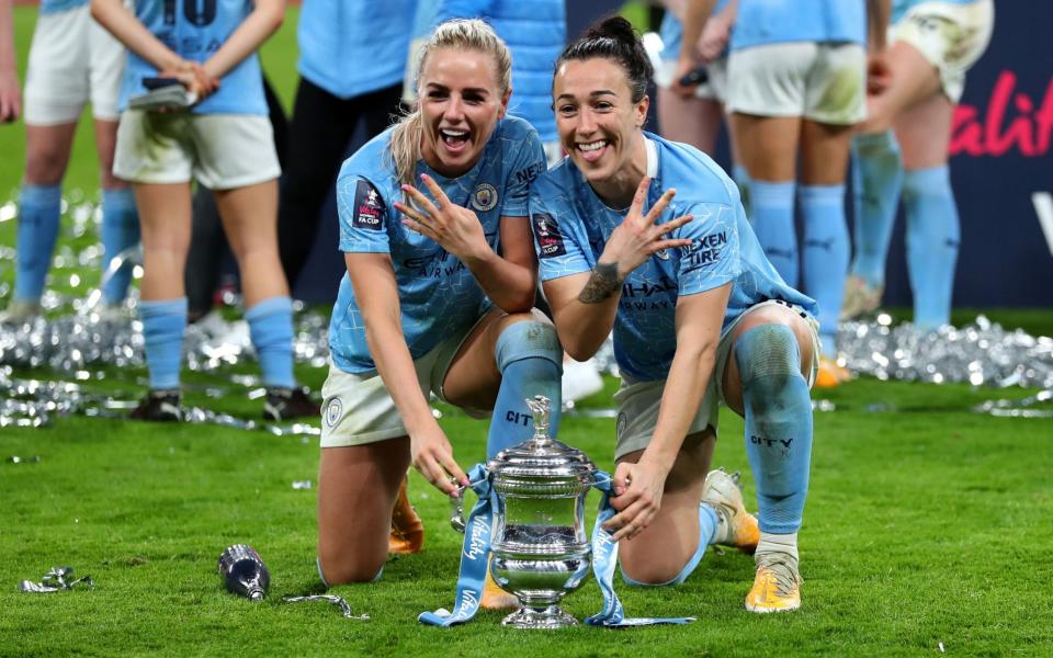 Alex Greenwood of Manchester City and Lucy Bronze of Manchester City celebrate with the Vitality Women's FA Cup Trophy following their team's victory in the Vitality Women's FA Cup Final match between Everton Women and Manchester City Women at Wembley Stadium on November 01, 2020 in London, England. Sporting stadiums around the UK remain under strict restrictions due to the Coronavirus Pandemic as Government social distancing laws prohibit fans inside venues resulting in games being played behind closed doors - Getty Images Europe /Catherine Ivill 