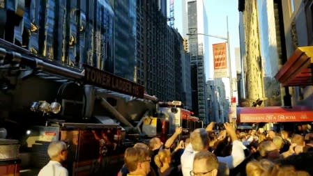 People evacuated from a Carnegie Hall concert during a blackout due to widespread power outages in the Manhattan borough of New York City, U.S, listen to the choir singing on the street in this still frame obtained via social media video