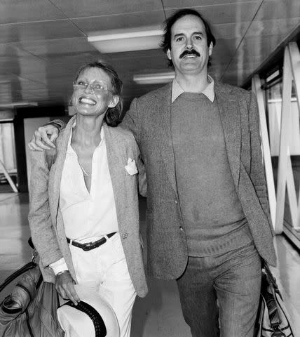 <p>Mirrorpix/Courtesy Everett</p> John Cleese (right) with wife Barbara Trentham in 1981