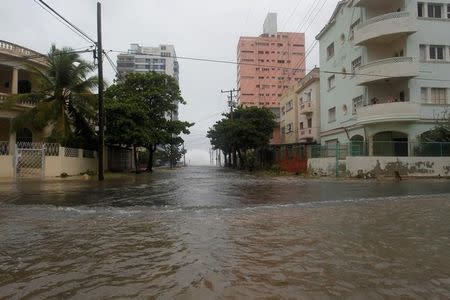 People look at the flooded street from a balcony as Hurricane Irma turns toward the Florida Keys on Saturday, in Havana, Cuba September 9, 2017. REUTERS/Stringer