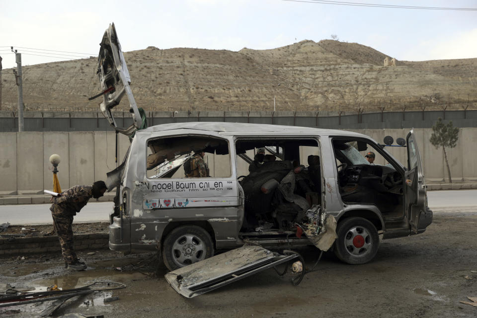 Security personnel inspect the site of a deadly bomb attack in Kabul, Afghanistan, Sunday, March 7, 2021. The bomb attached to minibus exploded Sunday in the capital, Kabul, killing and wounding several people. (AP Photo/Rahmat Gul)