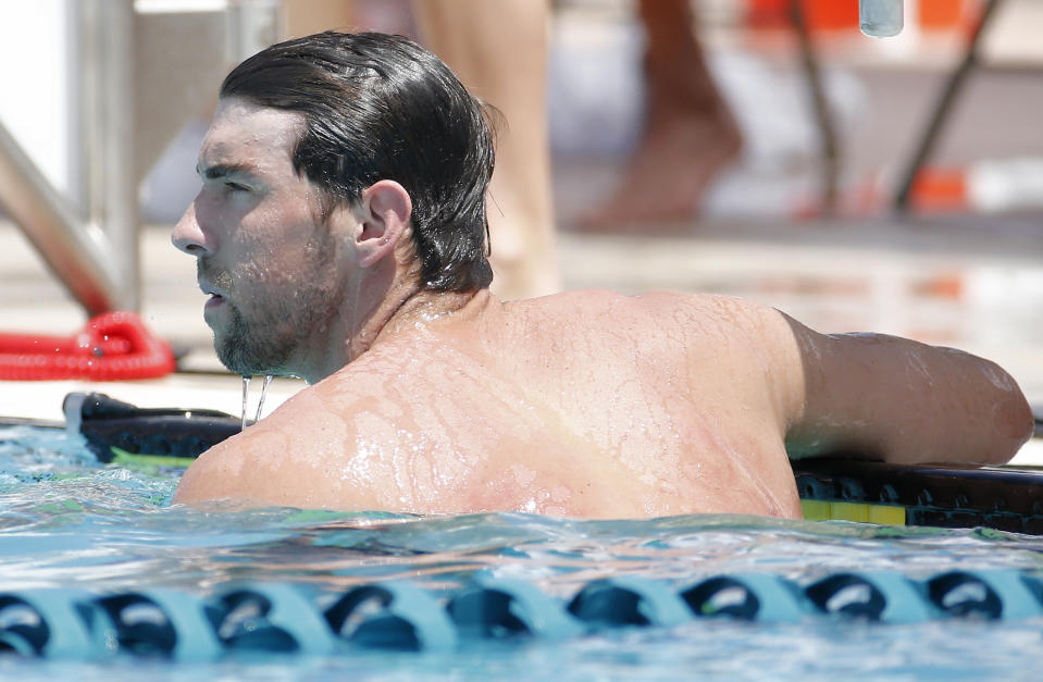 Michael Phelps looks at the scoreboard after the 100-meter butterfly during the Arena Grand Prix swim meet, Thursday, April 24, 2014, in Mesa, Ariz. It is Phelps' first competitive event after a nearly two-year retirement. (AP Photo/Matt York)