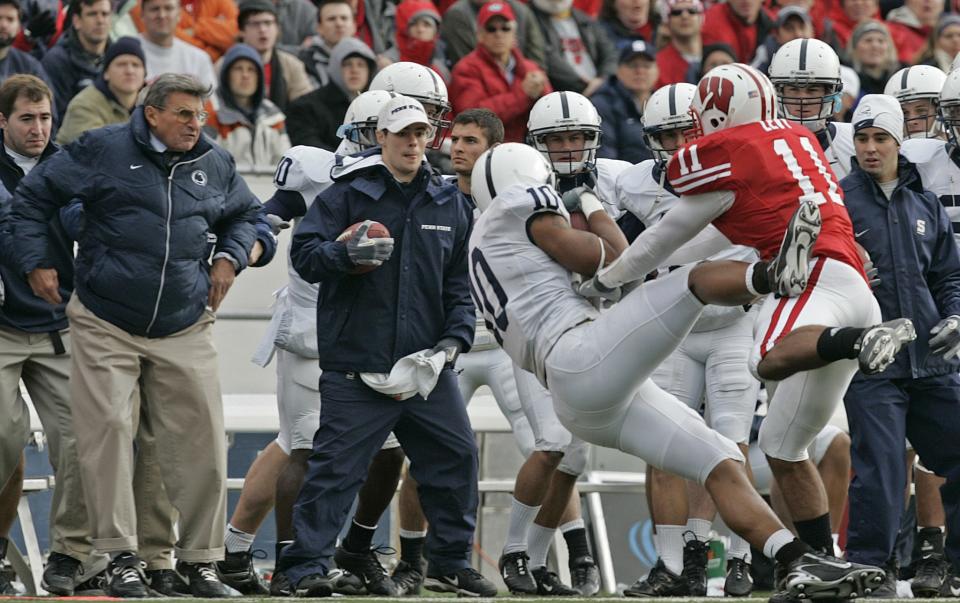 Penn State coach Joe Paterno, left, watches as Wisconsin's DeAndre Levy (11) knocks Penn State's Andrew Quarless out-of-bounds during the second half of a football game against Wisconsin Saturday, Nov. 4, 2006, in Madison, Wis. Paterno was hurt on the play and left the game. (AP Photo/Andy Manis)