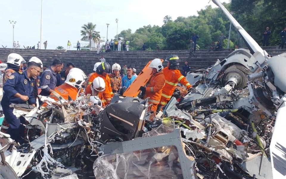 Emergency personnel work at the site of a helicopter crash in Lumut, Perak, Malaysia