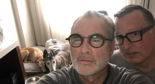 Brian Nilson, left, says he doesn't feel safe after learning there were COVID-19 cases at the hotel he's been required to self-isolate at with his husband, Alan Nilson, and their two dogs, as part of their move from Ontario to New Brunswick. (Submitted by Brian Nilson - image credit)