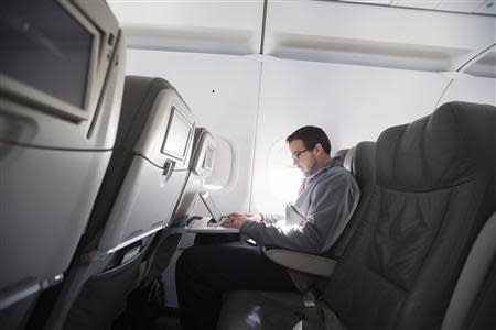 A man uses his laptop to test a new high speed in-flight Internet service named Fli-Fi while on a special JetBlue media flight out of John F. Kennedy International Airport in New York, in this file picture taken December 11, 2013. REUTERS/Lucas Jackson/Files