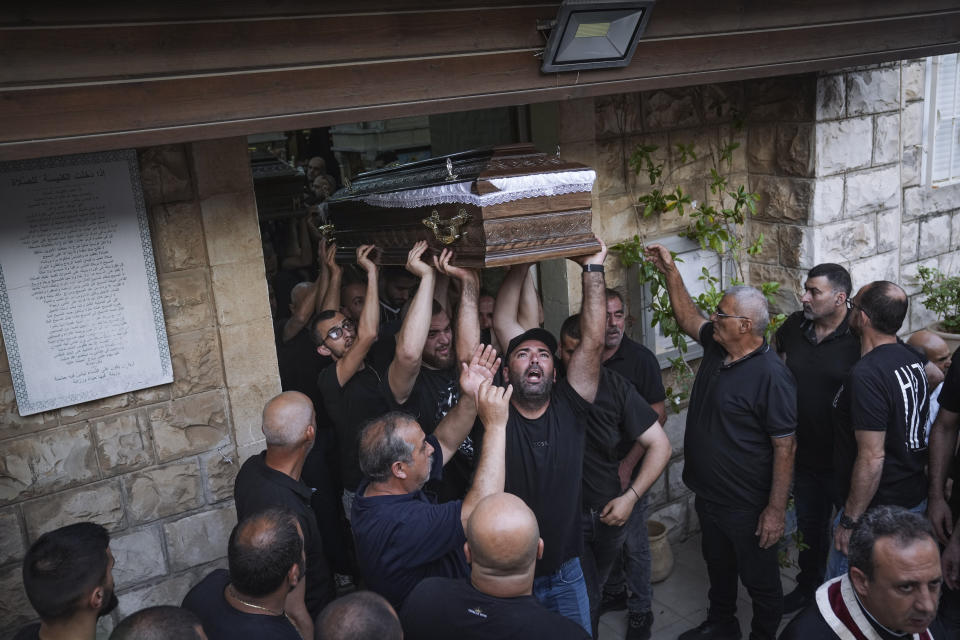 Mourners carry the coffins of two of the five Palestinian citizens of Israel, killed a day earlier when a gunman opened fire at a car wash in Yafa an-Naseriyye, near the city of Nazareth, Israel, during their funeral, Thursday, June 8, 2023. More than 100 people have been killed in violent crime in Arab communities since the start of this year, more than three times higher than at the same time last year. (AP Photo/Mahmoud Illean)